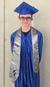a young man poses in his cap and gown