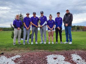 a golf team poses on green grass