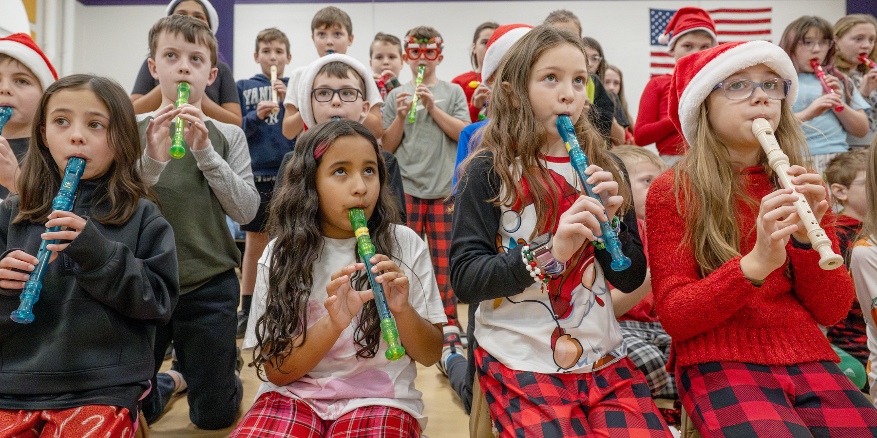 young students wearing pajamas play recorders