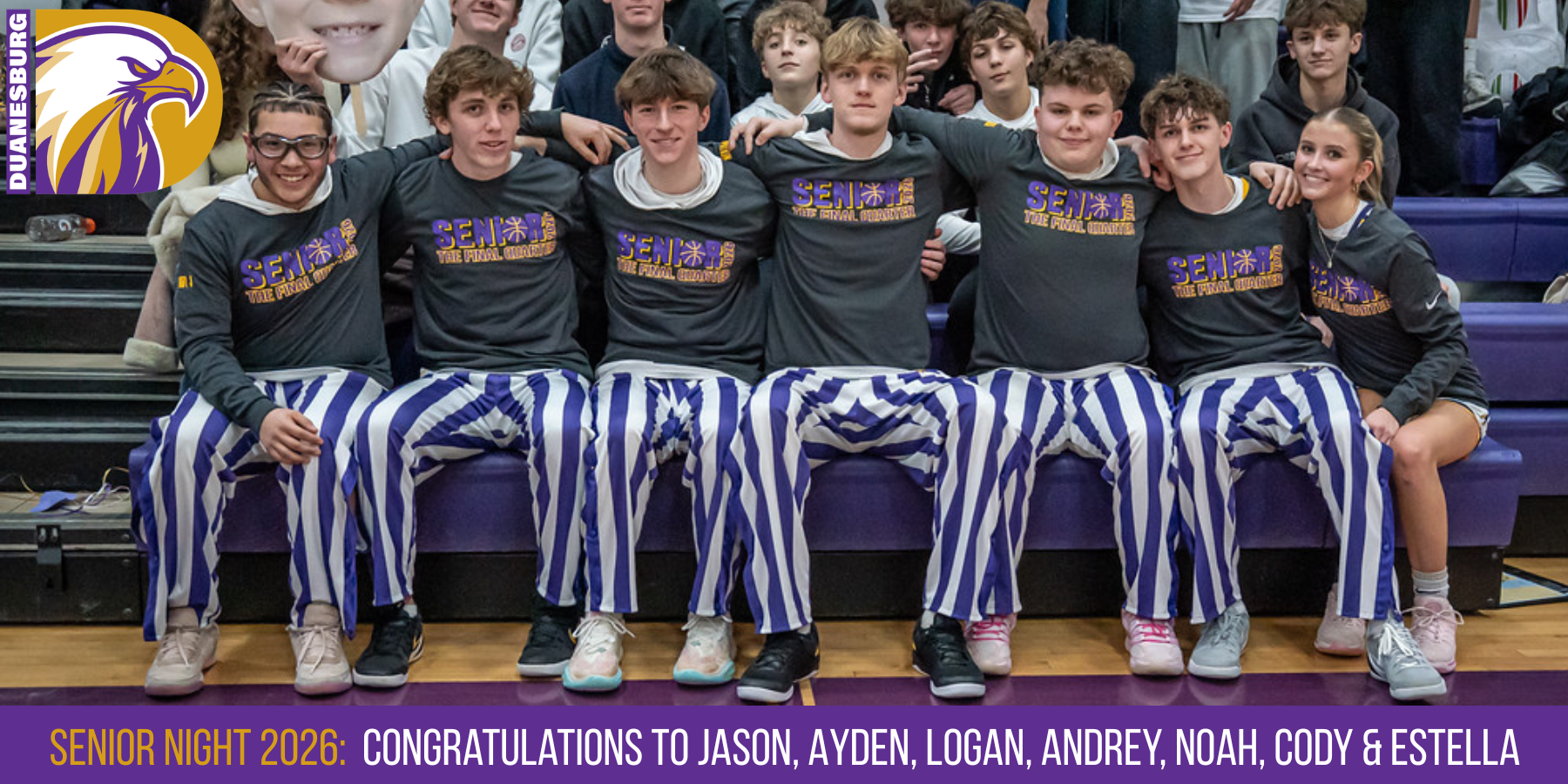 a group of male an female basketball players pose on a bench in a gymnasium