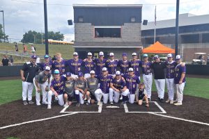 a baseball team poses outside on a baseball field