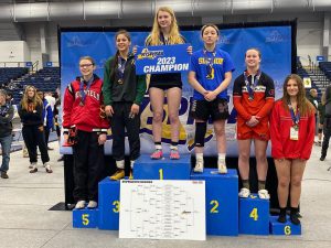 six female teenage athletes stand on a podium