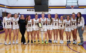 girls on a basketball team pose on the court