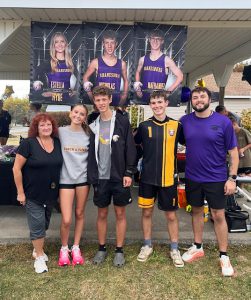 three athletes stand in between two coaches