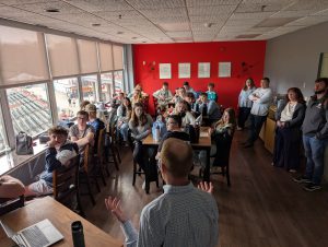 students listen to a man give a presentation
