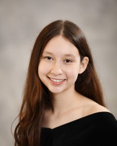 a traditional senior portrait with a young woman with long dark hair, wearing a black top