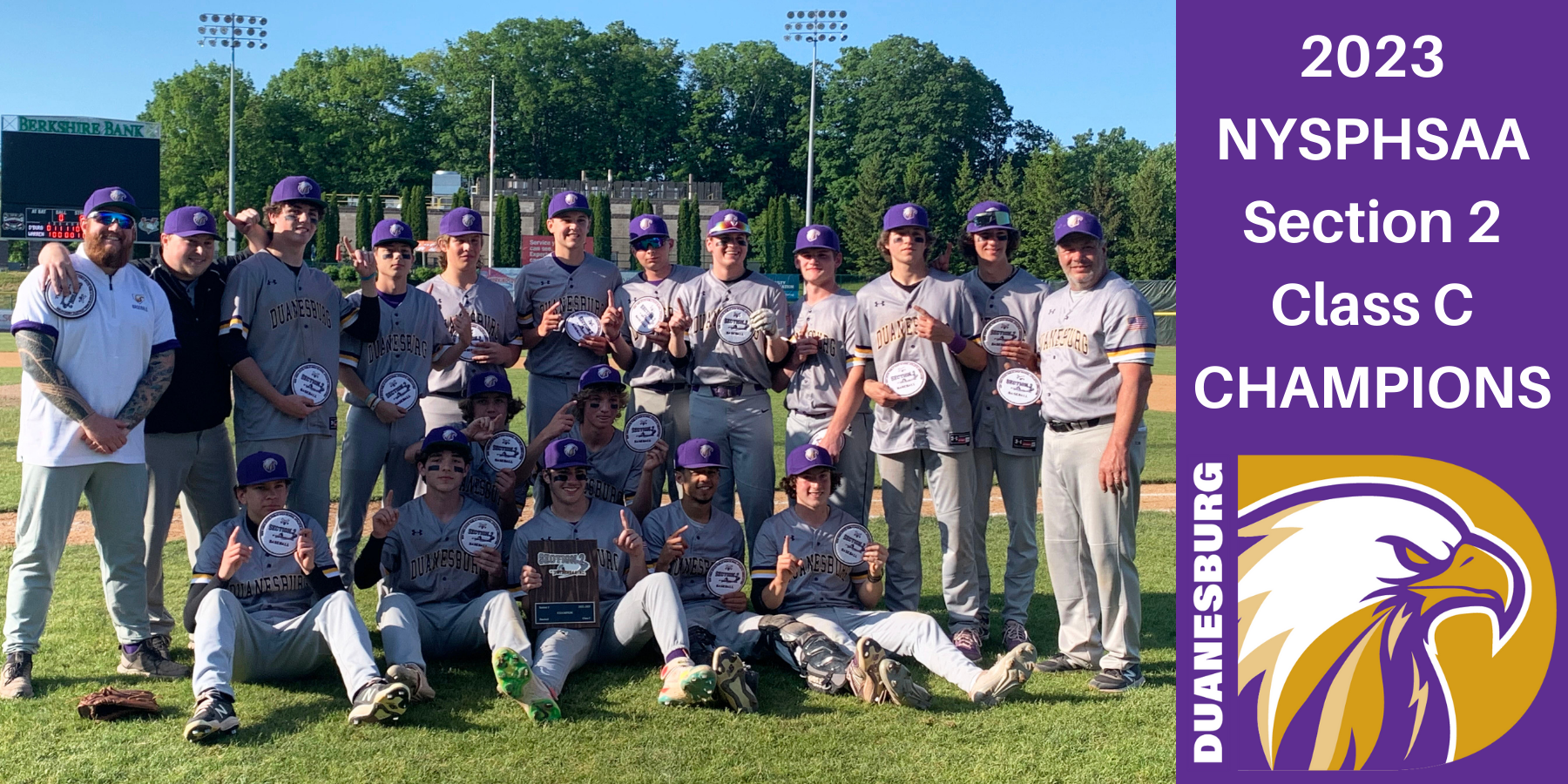 a baseball team poses with trophies on a baseball field, with a purple graphic background that has an eagle logo and the words "2023 NYSPHSAA Section 2 Class C Champions."