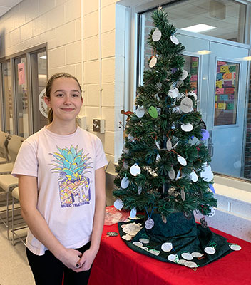 Breeanna Moss stands next to the Giving Tree