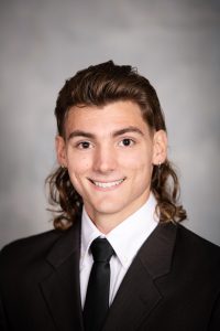 a boy with a bowtie poses for a senior portrait