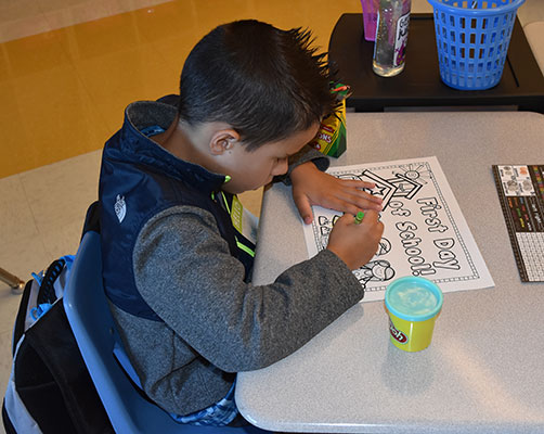 boy sitting at desk in elementary classroom