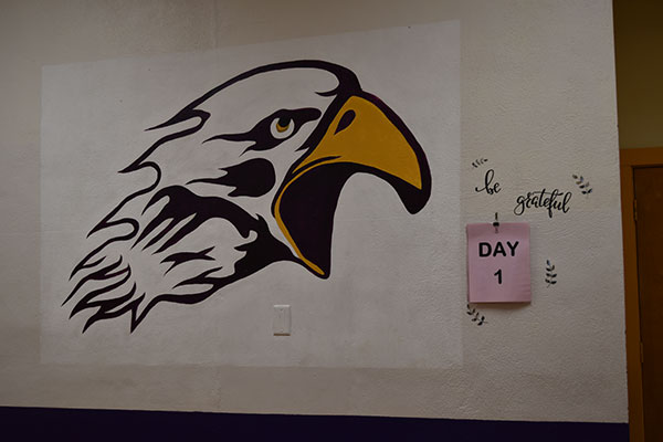 Eagle logo with day one on sticky note on wall