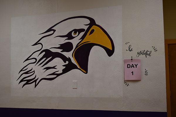 Eagle logo with day one on sticky note on wall