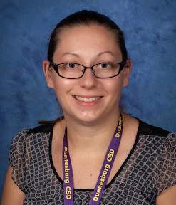 a woman wearing glasses in front of a blue backdrop