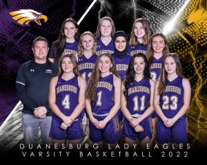 a girls basketball team poses with purple jerseys, along side their coach who is wearing a black shirt
