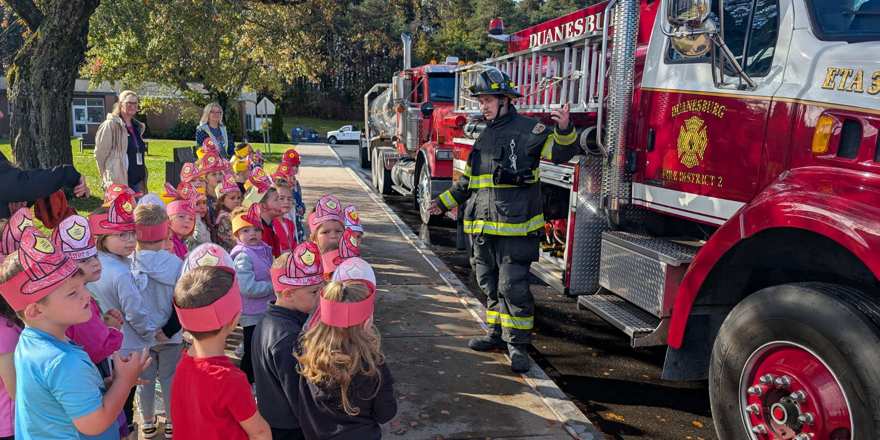young students listen to a presentation from a firefighter