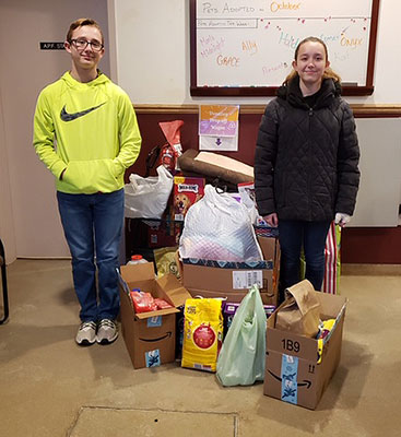 Wyatt and Breeanna Moss pose by Giving Tree donations