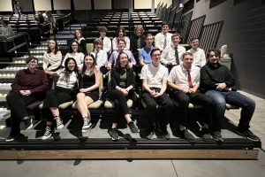 a group of students sit in theater seats in an auditorium