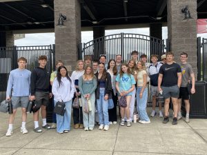 students pose outside of an athletic stadium