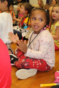 a young student applauds during an assembly