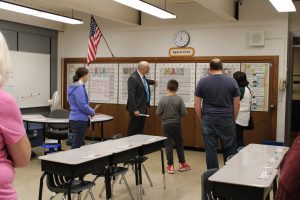 a group tours a classroom and looks at outdated storage closets