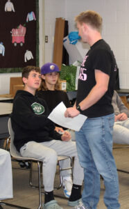 an adult male shakes hands with a young student