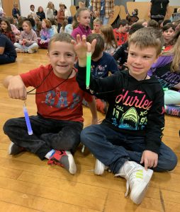 two male students wave glow sticks