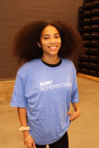 a young female student poses in a blue SUNY Schenectady t-shirt