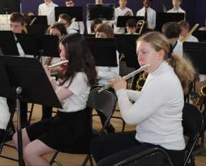 a young girl plays a flute