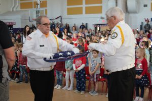 two men fold a flag