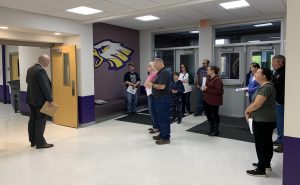 a group of community members meet at the entrance of a building