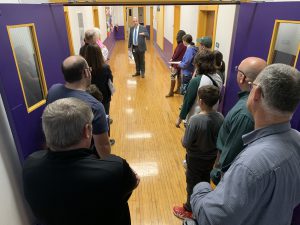 a group takes a tour of a school building with wood floors