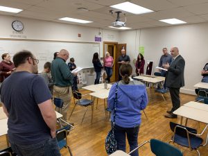 a group takes a tour of a classroom with wooden floors