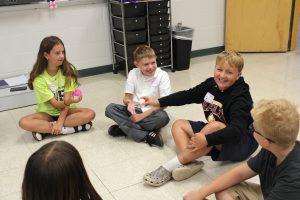 students sit on the floor in a circle