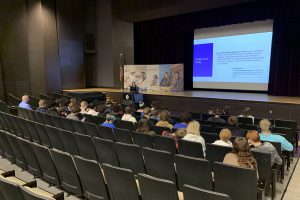 a woman presents to a group of students in an auditorium