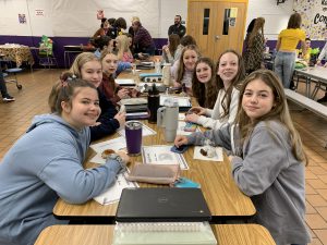 female students sit at a table in the cafeteria