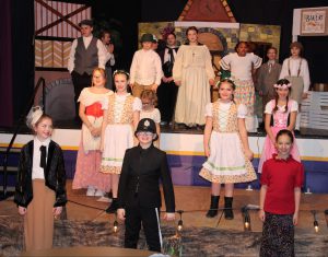 students in costume perform on a theatrical stage