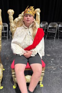 a young boy is dressed up as a king on a theatrical stage