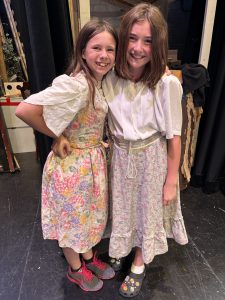 two girls pose backstage while rehearsing a play