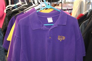 a purple button down shirt has a yellow emblem on it