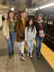 four teenagers pose on a subway platform