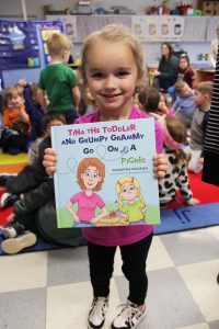 a young girl holds a book