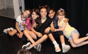 young students pose backstage on a theatrical stage