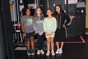 four young female students pose backstage in a theater