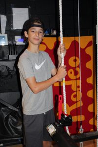 a young boy pulls a curtain rope back stage in a theater