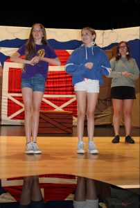 two girls sing on stage