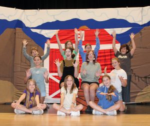 a group of students perform a musical number on a theatrical stage