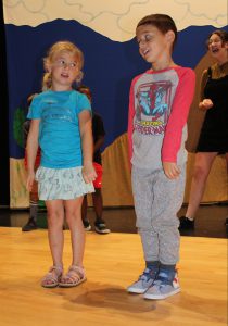 two young students perform on stage