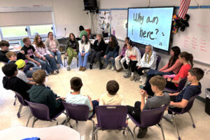 students sit around in a circle in a classroom