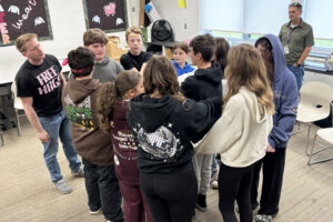 students form a huddle in a classroom