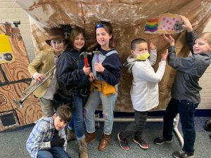 a group of co-ed elementary students work on a set piece for a performance